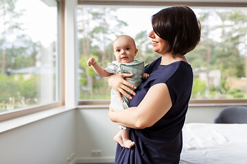 Image showing middle-aged mother holding baby daughter at home