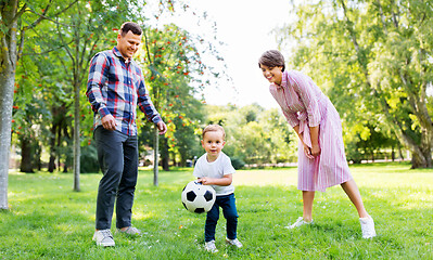Image showing happy family playing soccer at summer park