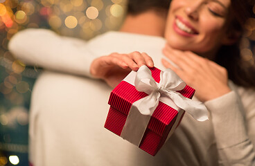 Image showing close up of couple with christmas gift hugging