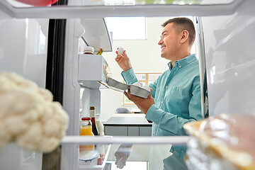 Image showing man taking eggs from fridge at kitchen