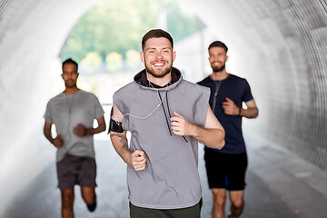 Image showing male friends with earphones running outdoors