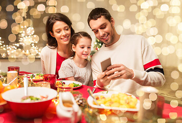 Image showing family with smartphone having christmas dinner