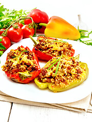 Image showing Pepper stuffed with meat and couscous in white plate on wooden b