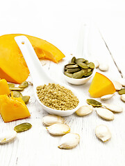 Image showing Flour and seeds pumpkin in spoons on wooden board