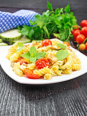 Image showing Fusilli with chicken and tomatoes in plate on wooden board