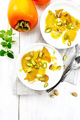 Image showing Dessert of yogurt and persimmon two bowls on board top