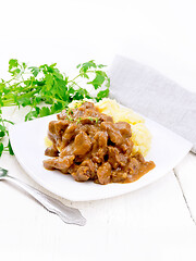 Image showing Goulash of beef with mashed potatoes in plate on light wooden bo