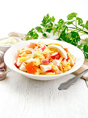 Image showing Salad of surimi and tomatoes with eggs on board