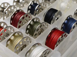 Image showing metal bobbins with multi-colored threads