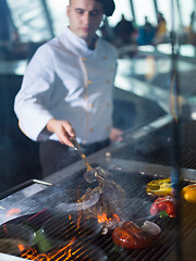 Image showing chef cooking steak with vegetables on a barbecue