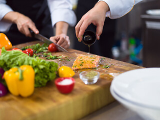 Image showing Chef hands preparing marinated Salmon fish