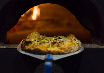 Image showing chef removing hot pizza from stove