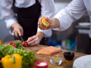 Image showing Chef hands preparing marinated Salmon fish