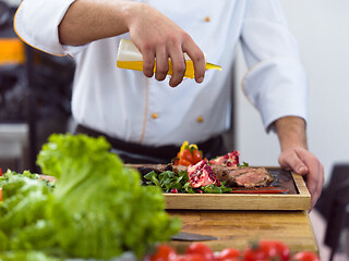 Image showing Chef finishing steak meat plate