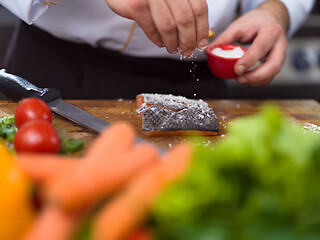 Image showing Chef hands preparing marinated Salmon fish