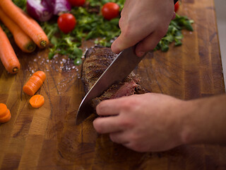 Image showing closeup of Chef hands preparing beef steak