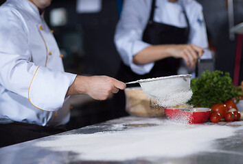 Image showing chef sprinkling flour over fresh pizza dough