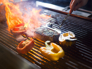 Image showing chef cooking steak with vegetables on a barbecue