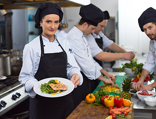 Image showing Chef holding dish of fried Salmon fish fillet