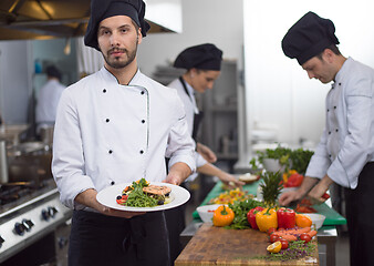 Image showing Chef holding dish of fried Salmon fish fillet