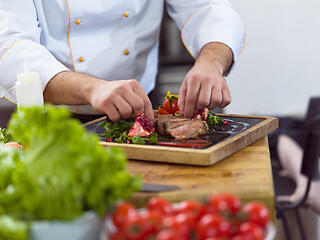 Image showing closeup of Chef hands serving beef steak