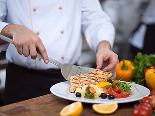 Image showing cook chef decorating garnishing prepared meal