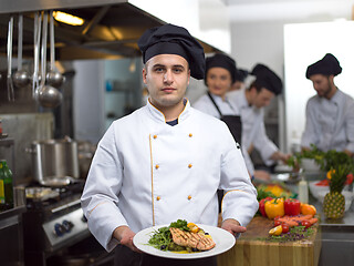 Image showing Chef holding dish of fried Salmon fish fillet