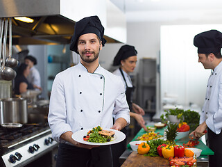 Image showing Chef holding dish of fried Salmon fish fillet