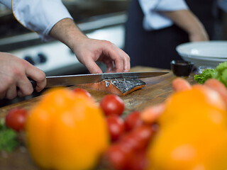 Image showing Chef hands preparing marinated Salmon fish