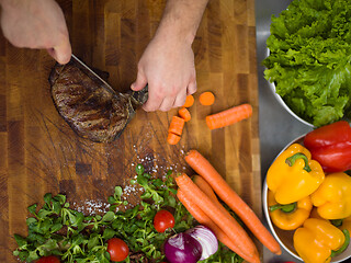 Image showing closeup of Chef hands preparing beef steak