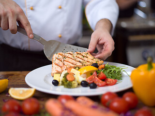 Image showing cook chef decorating garnishing prepared meal