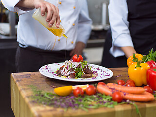 Image showing Chef finishing steak meat plate