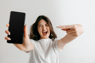 Image showing Portrait of a confident casual asian girl showing blank screen of mobile phone