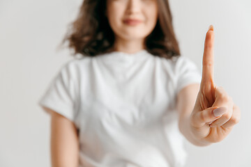 Image showing Woman\'s hand with finger on gray background