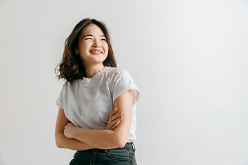 Image showing Happy asian woman standing and smiling against gray background.