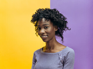 Image showing The happy african woman standing and smiling against gray background.