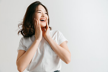 Image showing Happy asian woman standing and smiling against gray background.