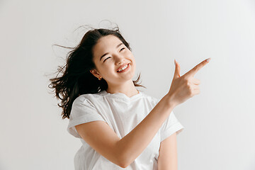 Image showing The happy asian woman standing and smiling against gray background.