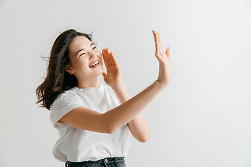 Image showing Isolated on pink young casual woman shouting at studio