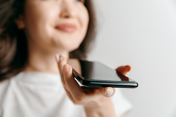 Image showing Indoor portrait of attractive young asian woman holding blank smartphone