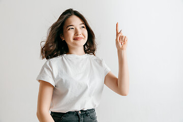 Image showing The happy asian woman standing and smiling against gray background.