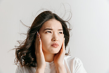 Image showing Woman having headache. Isolated over gray background.