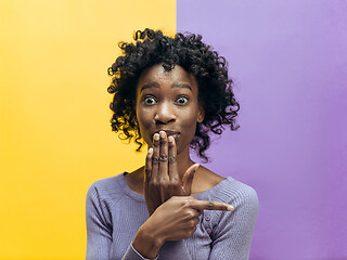 Image showing The young woman whispering a secret behind her hand