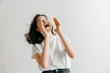 Image showing Isolated on pink young casual woman shouting at studio