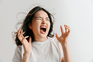 Image showing The young emotional angry woman screaming on gray studio background