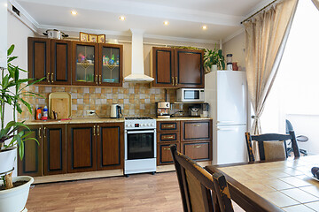 Image showing Classic wood grain kitchen set and dining table in the interior of the kitchen