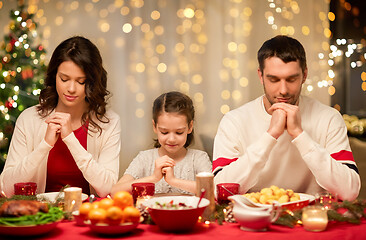 Image showing family praying before meal at christmas dinner