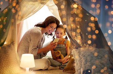 Image showing happy family with smartphone in kids tent at home