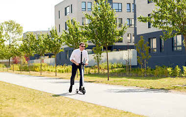 Image showing young businessman riding electric scooter outdoors