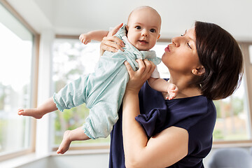 Image showing middle-aged mother holding baby daughter at home